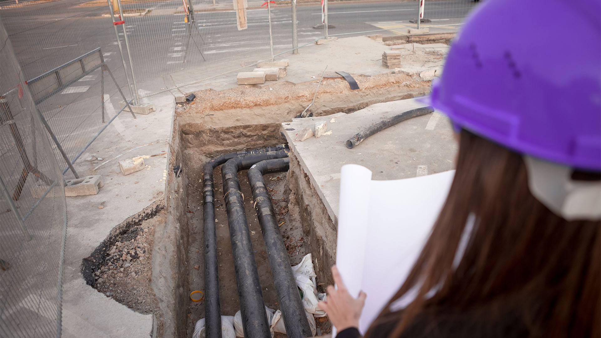 Mulher segurando o projeto hidráulico de uma construção.